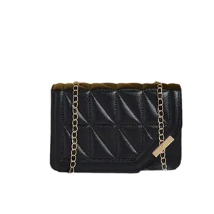 Black leather crossbody bag with geometric triangle quilting and gold chain strap