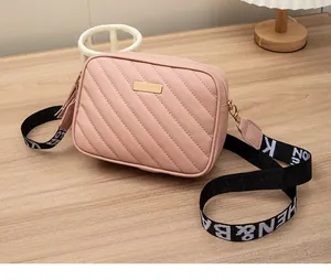 Borsa a tracolla trapuntata rosa con hardware dorato, nappina in pelle e tracolla larga