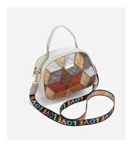 Detail of grey crossbody bag with multicolor crocodile pattern and wide logo strap