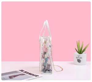 Side view of white daisy print PVC handbag with gold chain strap and leather handles