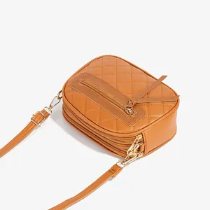 Brown quilted leather crossbody bag with multiple zipper compartments and tassel charm