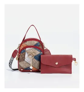 Detail of red quilted mini backpack and matching wallet with cat-themed pearl charm