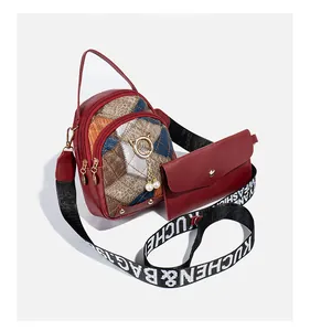Detail of red quilted mini bag set with cat charm, pearl tassel and wide logo strap