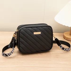 Borsa a tracolla trapuntata nera con placca dorata e ampia tracolla con scritte