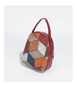 Detail of multi-color patchwork mini bag with crocodile texture and gold hardware