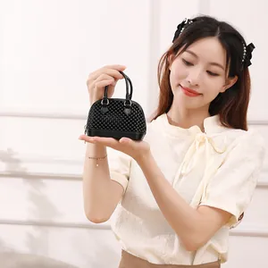 Handheld black shell-shaped beaded mini jelly bag for women in a lifestyle setting