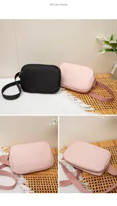 Detailansicht minimalistischer Nylon-Umhängetaschen in Schwarz und Rosa mit breitem Gurt