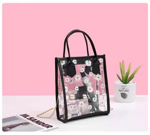 Detail of transparent PVC tote bag with daisy print, gold chain, and storage capacity