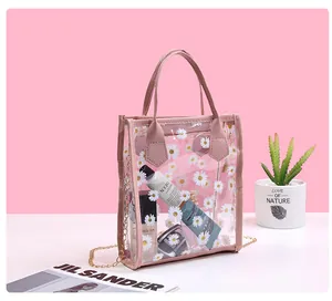 Detailed view of clear PVC daisy bag with pink trim holding cosmetics and perfumes