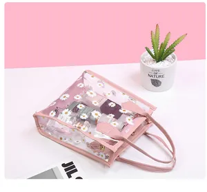 Detailed view of clear PVC daisy print tote bag showing storage of pink cosmetics