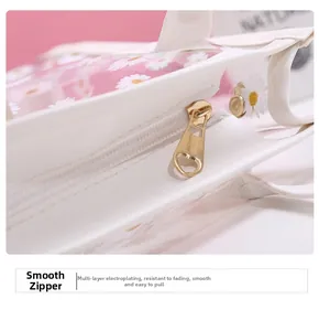 Detail eines glatten goldenen Metallreißverschlusses an einer PVC-Tasche mit Gänseblümchen