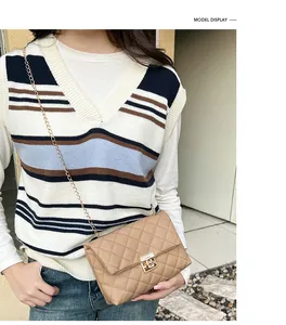 Close-up of beige quilted crossbody bag with gold chain strap worn by a model
