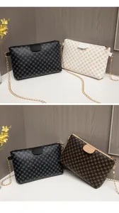Detailed close-up of textured leather bags in black white and brown with gold chain straps