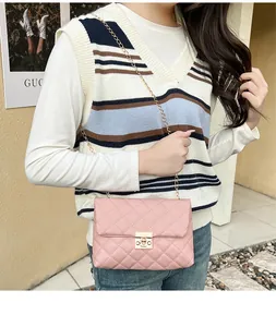 Detailed shot of pink quilted crossbody bag with gold chain strap and metal lock closure