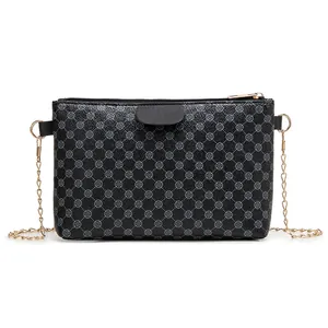 Black ladies crossbody bag with clover pattern and gold chain strap on white background