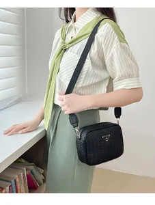 Detail of black woven camera bag with thick nylon strap and golden metal buckles
