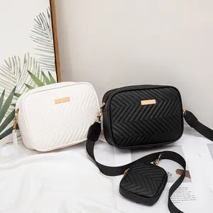 Quilted chevron crossbody bag in black and white with wide strap and mini pouch