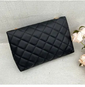 Close-up of black quilted leather texture and intricate diamond stitching on chain bag
