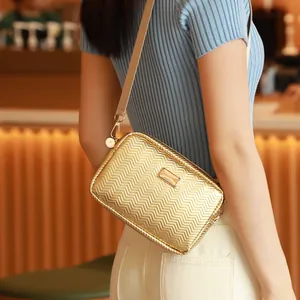 Elegante bolso bandolera dorado con textura de espiga y acabado metálico brillante