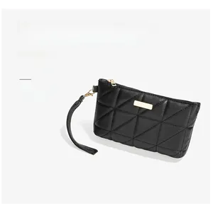 Detail of black quilted mini bag featuring triangular stitching and gold hardware