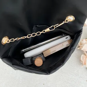 Black quilted crossbody bag with gold chain strap showing spacious internal capacity