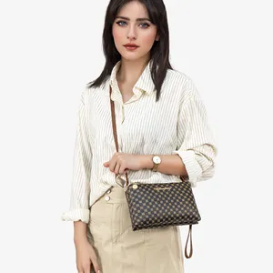 Elegant brown crossbody bag with gold circle patterns and a leather strap for women