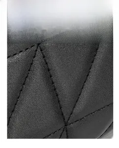 Macro detail of black leather bag featuring classic quilted diamond pattern and fine stitching