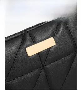 Macro shot of black leather handbag featuring geometric stitching and gold metal hardware