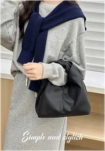 Detail of black cloud hobo bag featuring premium lychee texture and soft pleats