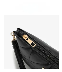 Detail of black quilted leather with gold metal zipper and refined matte texture