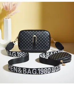 Detail of crossbody camera bag with circle pattern and wide webbed logo strap