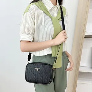 Black woven texture camera bag for women with golden triangular plaque and adjustable strap