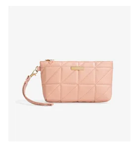 Detail of pink quilted handbag with triangular embroidery and gold-tone hardware