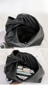 Detail of black pebbled leather cloud bag showing spacious interior for daily essentials