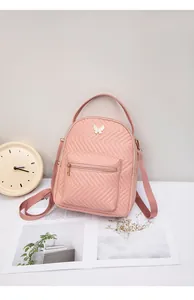 Detailed view of pink chevron quilted mini backpack featuring a gold butterfly buckle