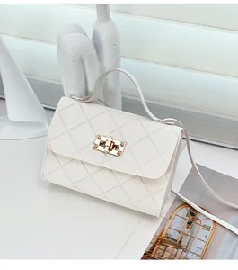Detail van de witte gewatteerde lederen textuur en gouden draaisluiting op de mini-tas