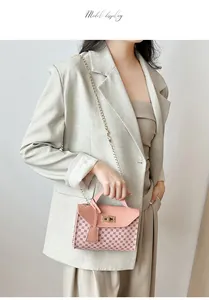 Detailed view of a pink monogram chain bag with gold metal lock worn by a model