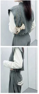 Detail of trendy metallic bow and lip shaped mini bags with fine silver chain straps
