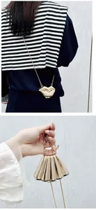 Detail of trendy gold lip shaped and fan style mini metal bags with delicate chain straps