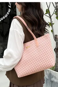 Pink tote bag with red geometric dots shown on a model in a stylish outdoor setting