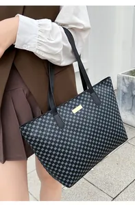 Detail view of large tote bag with blue geometric pattern and gold metal hardware