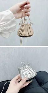 Detail of mini shell-shaped metallic bags in gold and silver with elegant chain straps