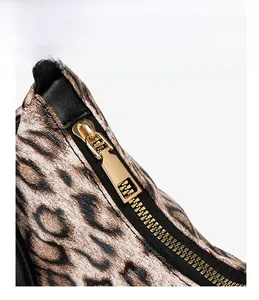 Détail macro du sac léopard en similicuir avec fermeture dorée et double couture
