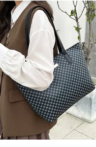 Detail of large tote bag with blue geometric pattern and gold brand plate