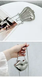 Close-up of silver shell and red lip shaped mini metal handbags with chain straps