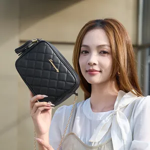 Black quilted crossbody camera bag with gold chain strap and decorative tassel