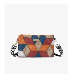 Close-up of color-block cube crossbody bag featuring mixed textures and metal detail