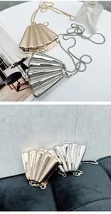 Close-up of elegant gold and silver seashell clutch bags with snake chain straps
