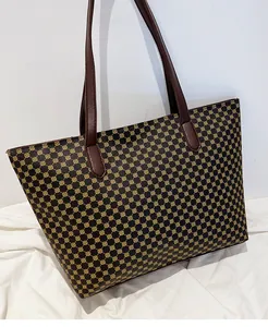 Detail of vintage geometric pattern and leather straps on large shoulder tote bag