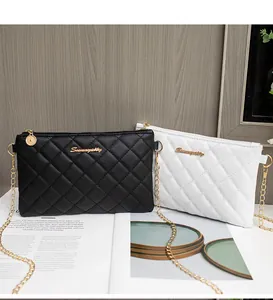 Détails du motif matelassé sur des sacs à bandoulière noir et blanc avec chaîne dorée